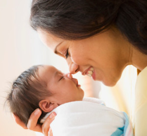 Mother rubbing noses with newborn baby girl