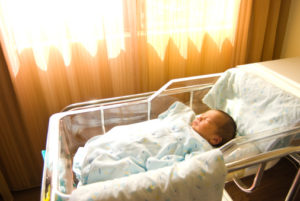 Newborn baby is sleeping in basket near window