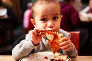 Boy eating pizza in restaurant