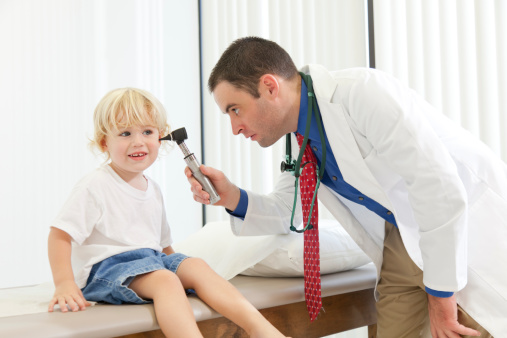 doctor examining child's ear to determine if he has an ear infection