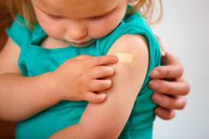 Little girl looking at plaster where she has had an injection