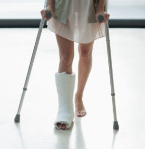 Person with cast on leg using crutches
