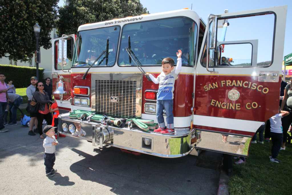 touch-a-truck event in san francisco little boy waiving on red firetruck