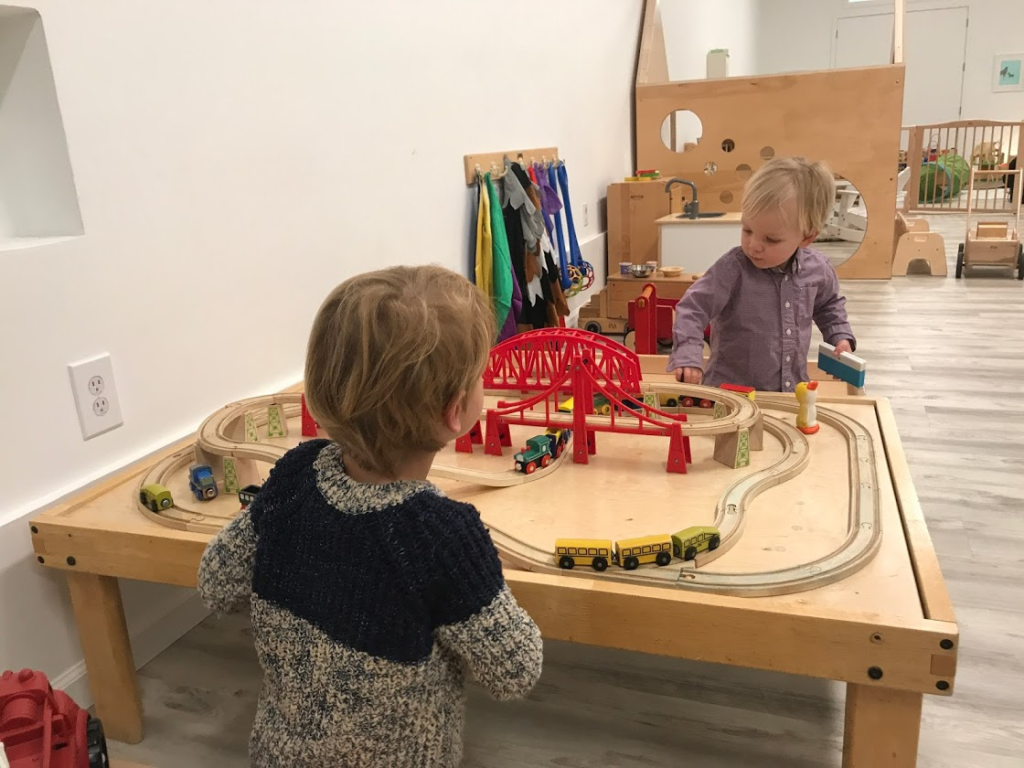 children playing at train table at Recess Collective's indoor play space in the Sunset neighborhood of San Francisco