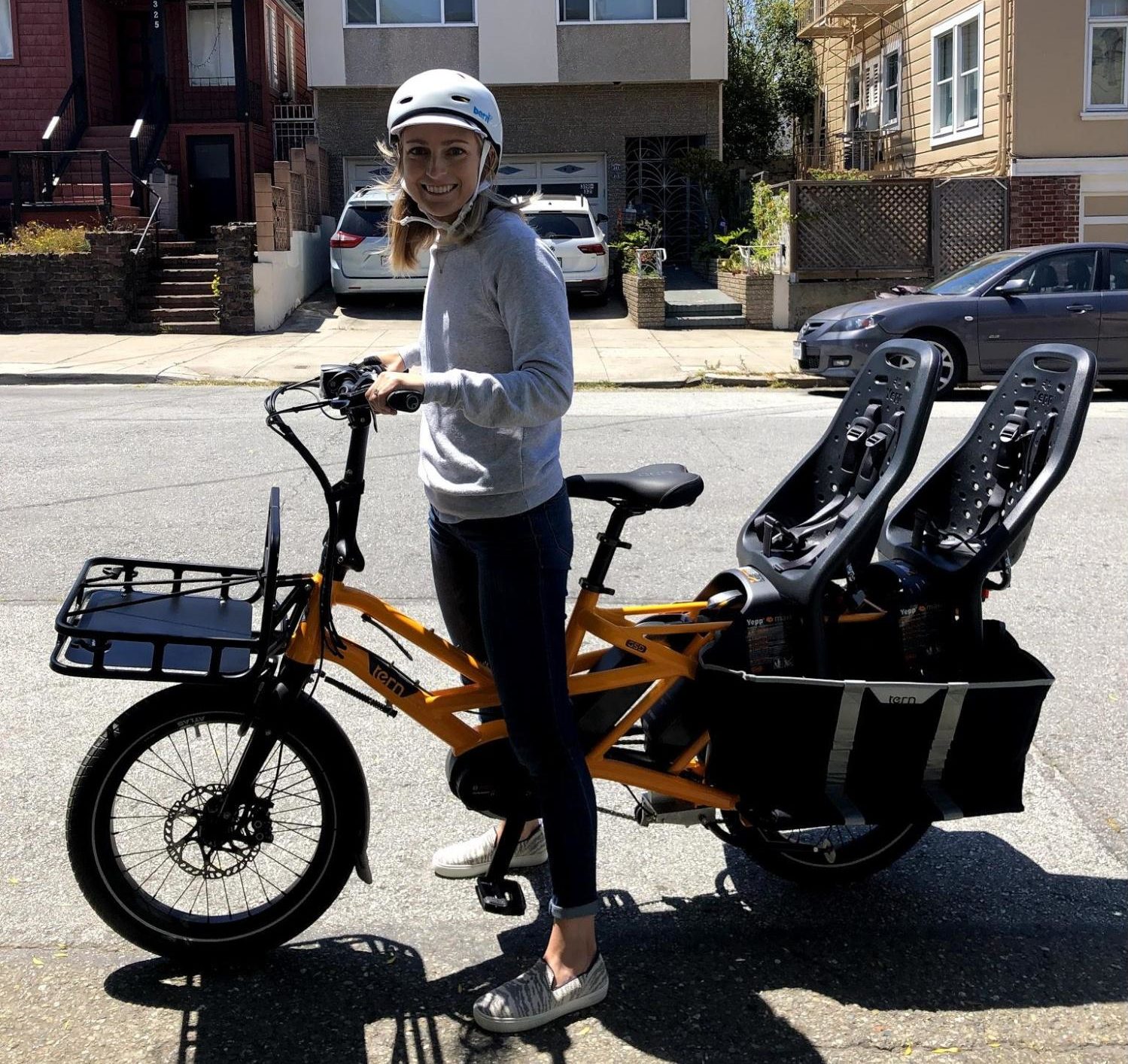 san francisco mom posed with her electric cargo bike that fits two toddlers