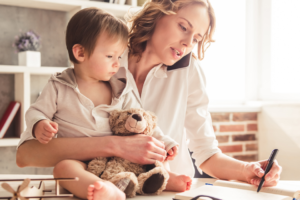 Mother working at home and caring for child