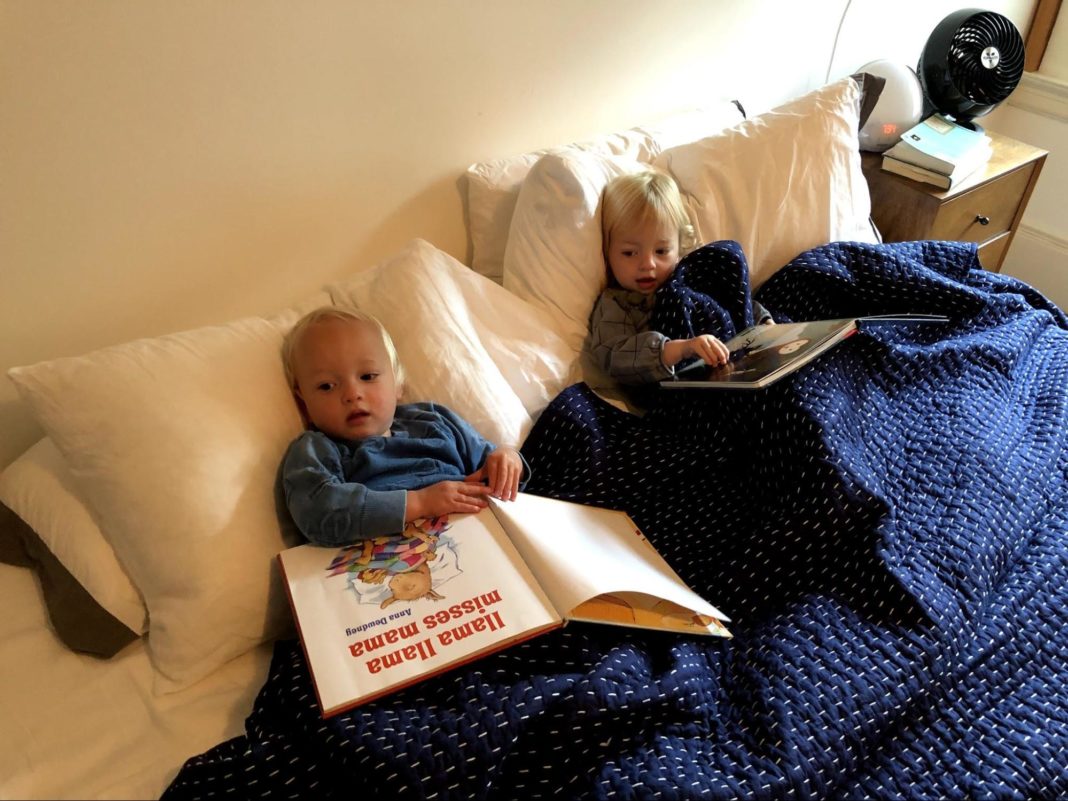twin toddlers laying in a bed