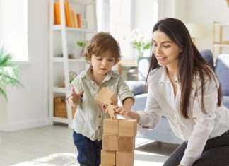 Fun Engineering Projects for Kids To Try at Home A mother and child playing with blocks in a well-lit living room. The child is placing a block on the tower.