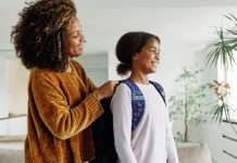 Calming Rituals To Start Every Busy Morning Right A mother and her daughter are smiling and talking as the mother helps her child put her backpack on for school.