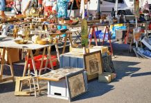 Easy DIY Decor Inspired by Bay Area Flea Markets Shoppers browse tables filled with vintage antiques, framed artwork, and collectibles at an outdoor flea market.