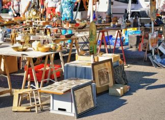 Easy DIY Decor Inspired by Bay Area Flea Markets Shoppers browse tables filled with vintage antiques, framed artwork, and collectibles at an outdoor flea market.