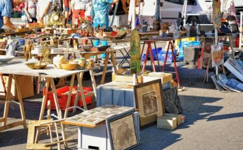 Easy DIY Decor Inspired by Bay Area Flea Markets Shoppers browse tables filled with vintage antiques, framed artwork, and collectibles at an outdoor flea market.