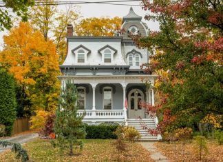 How to Make an Older House Feel More Modern A large historic house with tall windows and a small porch. The trees around the house are changing colors.